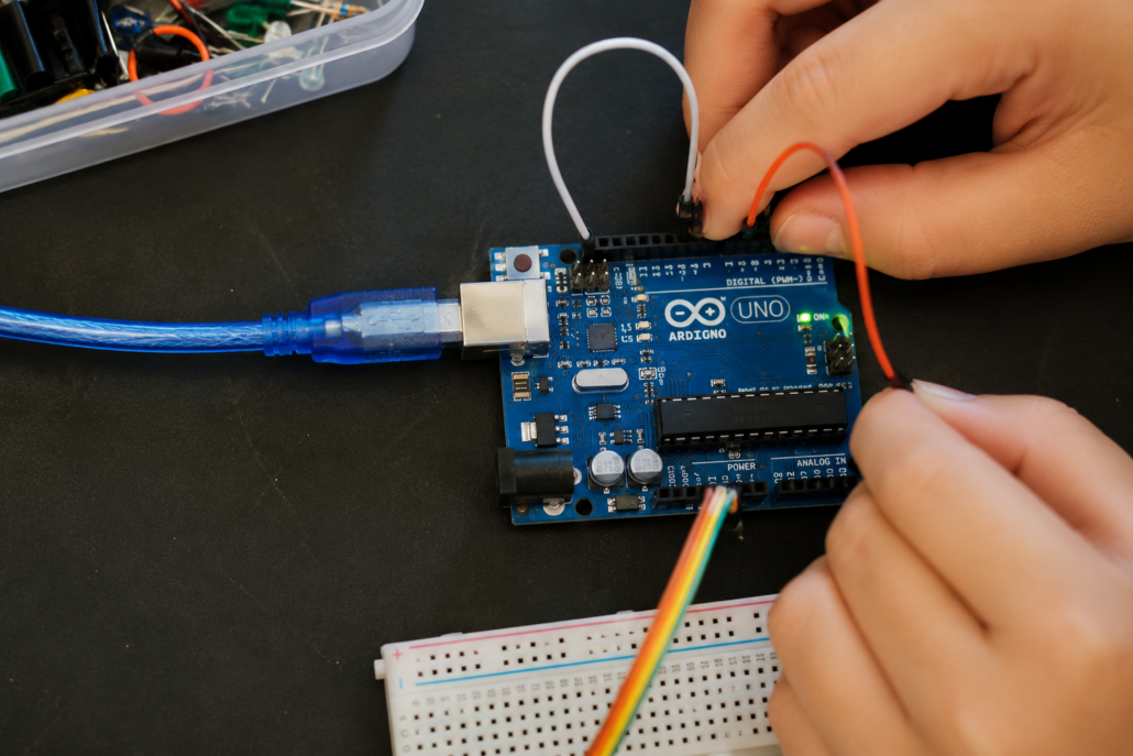 Child hands working with Arduino circuit board in robotics class at MakerKids Toronto